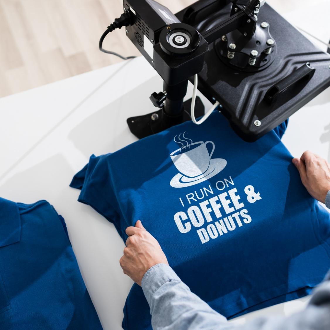 A man heat pressing a quote in white DTF ink onto a blue polo shirt using the DTF printing method, illustrating the outstanding results and efficiency of this textile printing technique.